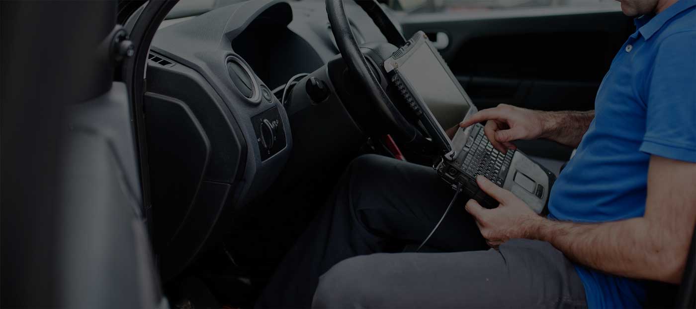 Tehnician efectuând o diagnoză auto computerizată în București