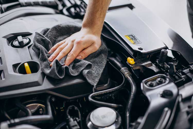 Mecanic lucrând la motorul unui autoturism în service